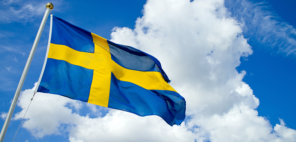 Bild på svenska flaggan mot himmel.