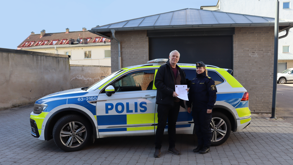 Kommunstyrelsens ordförande Peter Lindberg (SD) och Anna Nilsson, lokalpolisområdeschef (Lpo) för Söderåsens polisområde står framför en polisbil utomhus.