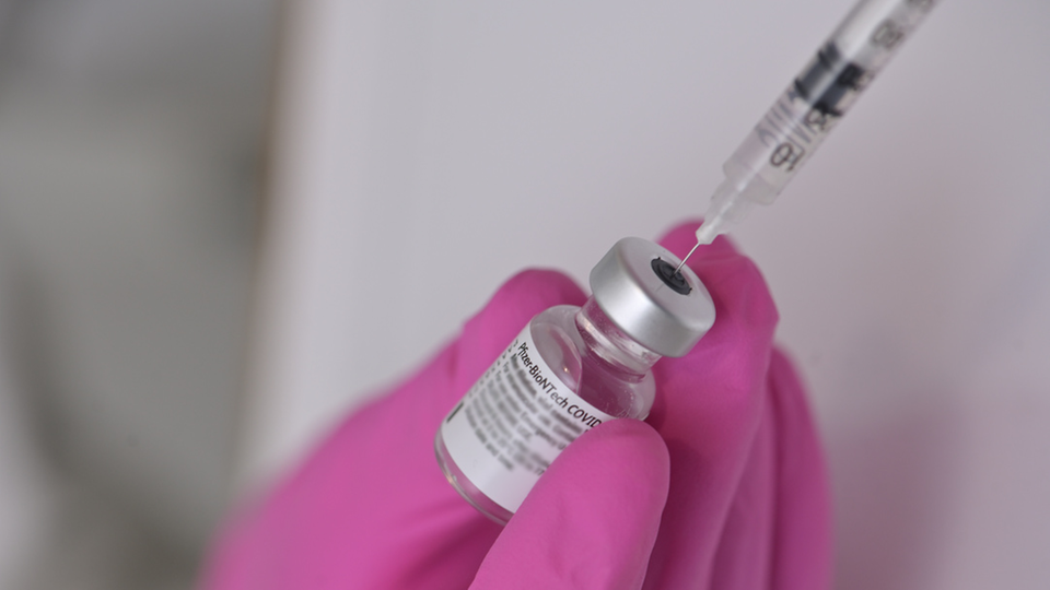 En behållare och spruta för vaccin mot covid19.