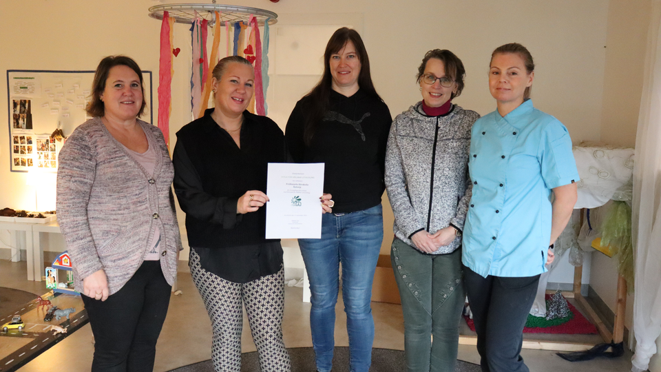 Personal på Fröhusets förskola håller upp ett diplom för utmärkelsen Skola för hållbar utveckling.